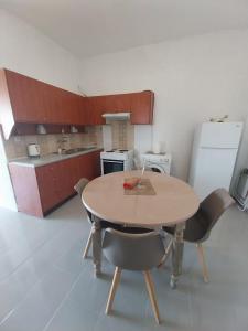 a kitchen with a table and chairs in a room at Εmmi in Koutsounari