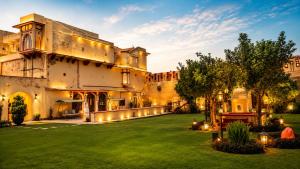 an exterior view of a building with a yard at Pachewar Garh - A Heritage Fort in Pachhewar
