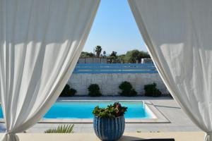 a view of a swimming pool through a white curtain at Villa Colapesce in Marzamemi