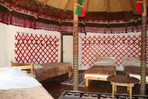 a room with three beds and a tent at Happy Nomads - Modern Yurt Cottages & Breakfast in Karakol +140 photos