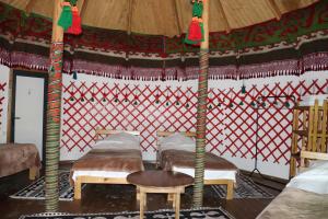 a room with three beds in a yurt at Happy Nomads - Modern Yurt Cottages & Breakfast in Karakol
