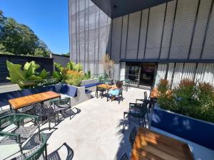 a woman sitting on a patio with tables and chairs at SKY design Alphaville by Rhouses in Barueri