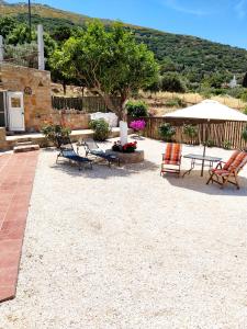 a patio with chairs and a table and a tree at villa lena πετρινο in Katákoilos