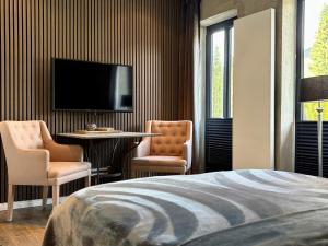 a bedroom with a bed and a table and a tv at country-suites by verdino LIVING - Apartments & Privatzimmer in Braunlage