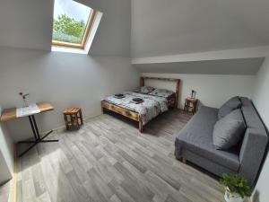 a bedroom with a bed and a couch and a window at Pension Alex in Benecko