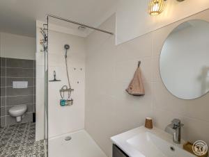 a white bathroom with a shower and a sink at Le Clos d'Artagnan in Valcabrère