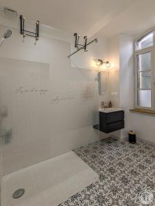 a bathroom with a shower with a sink and a mirror at Le Clos d'Artagnan in Valcabrère