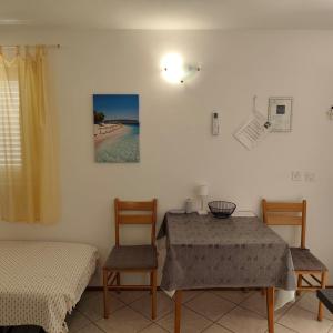 a room with a table and two chairs and a bed at Apartments Ada in Primošten