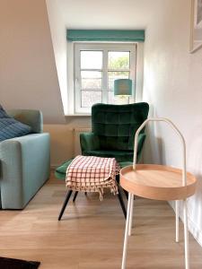 a living room with a green chair and a table at Inselglück Föhr in Wrixum