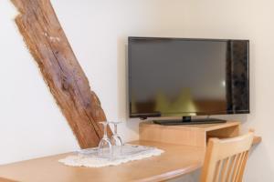 a table with two wine glasses and a television at Micheli Hermann Obst- und Weinbauernhof mit "Südtirol Alto Adige Guest Pass - Mobilcard" in Caldaro