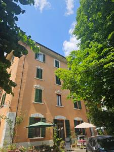 a large brick building with green shuttered windows and an umbrella at Albergo Ristorante Guidi in Pistoia
