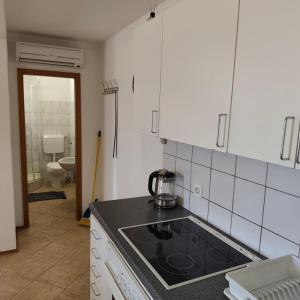 a kitchen with a stove top oven next to a bathroom at Apartments Ada in Primošten +38 photos