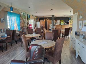 a dining room with tables and chairs in a restaurant at Luigeranna B&B in Küdema