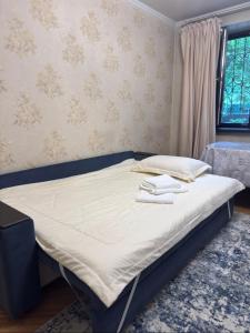 a bed in a bedroom with a blue frame at Apartment in Almaty