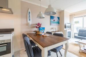 a kitchen and dining room with a table and chairs at Appartementencomplex Juliana 148 in De Koog
