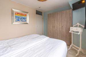 a bedroom with a white bed and a closet at Appartementencomplex Juliana 148 in De Koog +5 photos