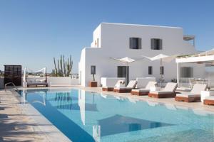 a swimming pool with lounge chairs and a villa at 18 Grapes Hotel in Agios Prokopios