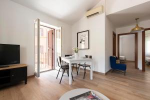 a living room with a table and a tv at Domus Fornaci in Rome