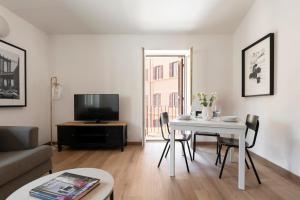 a living room with a white table and a tv at Domus Fornaci in Rome