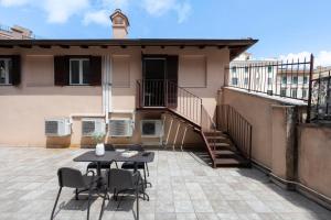 a patio with a table and chairs in front of a building at Domus Fornaci in Rome