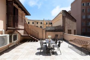 a patio with a table and chairs on a balcony at Domus Fornaci in Rome