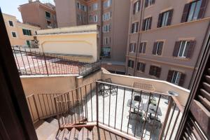 a balcony with chairs and tables in a building at Domus Fornaci in Rome +60 photos