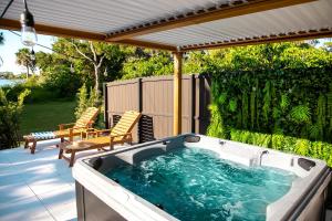 a hot tub on a patio with two chairs at Boho Bliss - Reset & Recharge Wellness House in Naples