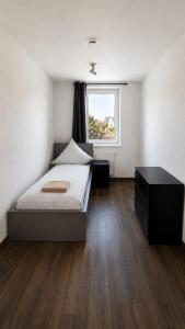 a bedroom with a bed and a window at Monteurwohnungen in Markranstädt in Markranstädt