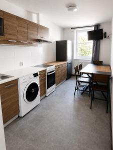 a kitchen with a washing machine and a table with chairs at Monteurwohnungen in Markranstädt in Markranstädt