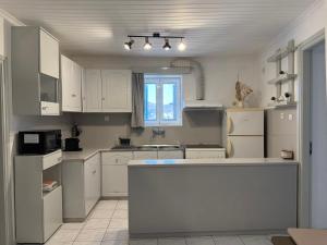 a kitchen with white cabinets and a island in it at Cycladic House Naxos in Glinado Naxos +40 photos