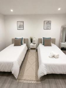 two beds sitting next to each other in a room at Casa do Mar Oeiras in Oeiras +29 photos