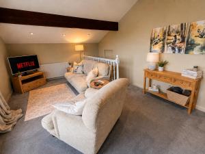 a living room with a couch and a tv at Paddock View Loft Countryside Retreat in Thornhill
