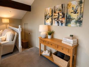 a living room with a table with a lamp and a chair at Paddock View Loft Countryside Retreat in Thornhill
