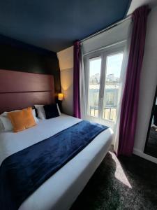 a bedroom with a bed and a large window at Accueil Hôtel Paris Pigalle Montmartre - Hôtel rénové in Paris