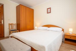 a bedroom with a white bed and a wooden cabinet at Blue Horizon Retreat in Trogir