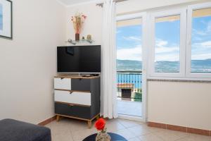 a living room with a tv and a large window at Blue Horizon Retreat in Trogir