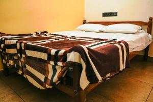 a bed with a blanket on it in a room at AnanthaSayanam Homestay Near Sri Padmanabha Swamy Temple in Trivandrum