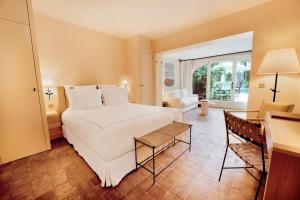 a bedroom with a white bed and a living room at La Bastide de Saint Tropez in Saint-Tropez +105 photos