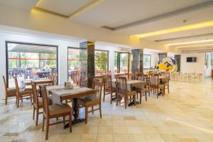 a restaurant with wooden tables and chairs and windows at Pirates Park Resort - All Inclusive in Kemer