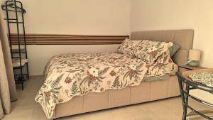 a bed with a comforter on it in a room at Studio Miška in Bohinjska Bela