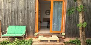 a green chair and a table on a patio at Studio Miška in Bohinjska Bela +7 photos