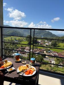 a table with plates of food on top of a balcony at FARILA LODGE in Kelimutu