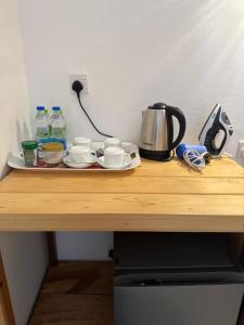 a table with a tray with cups and a tea kettle at Ella Nine Arch lodge in Ella
