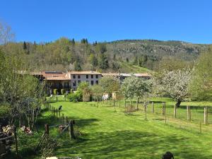 a building in the middle of a field with trees at Le rouge Robin in Fougax-et-Barrineuf