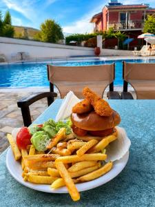 a plate of food with a chicken sandwich and french fries at Art Studios Benitses in Benitses