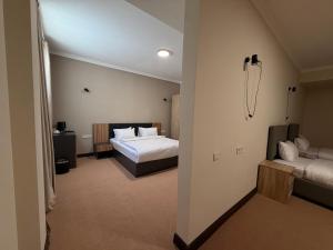 ein Hotelzimmer mit einem Bett und einer Couch in der Unterkunft Sheldon Hotel in Yerevan