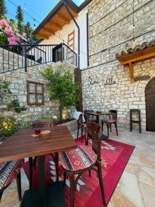 a patio with tables and chairs and a brick wall at Stone Villa Berat in Berat
