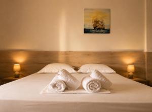 a bedroom with a bed with towels on it at Vila Gjoni in Sarandë