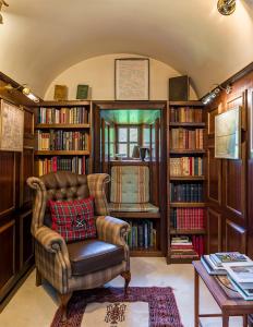 a living room with a chair and book shelves at Lickleyhead Castle in Insch +42 photos