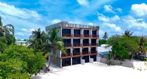 an apartment building on the beach with palm trees at Valley Palm Seaview in Guraidhoo